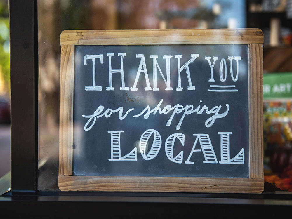 A sign in a shop window saying 'Thank you for shopping local'